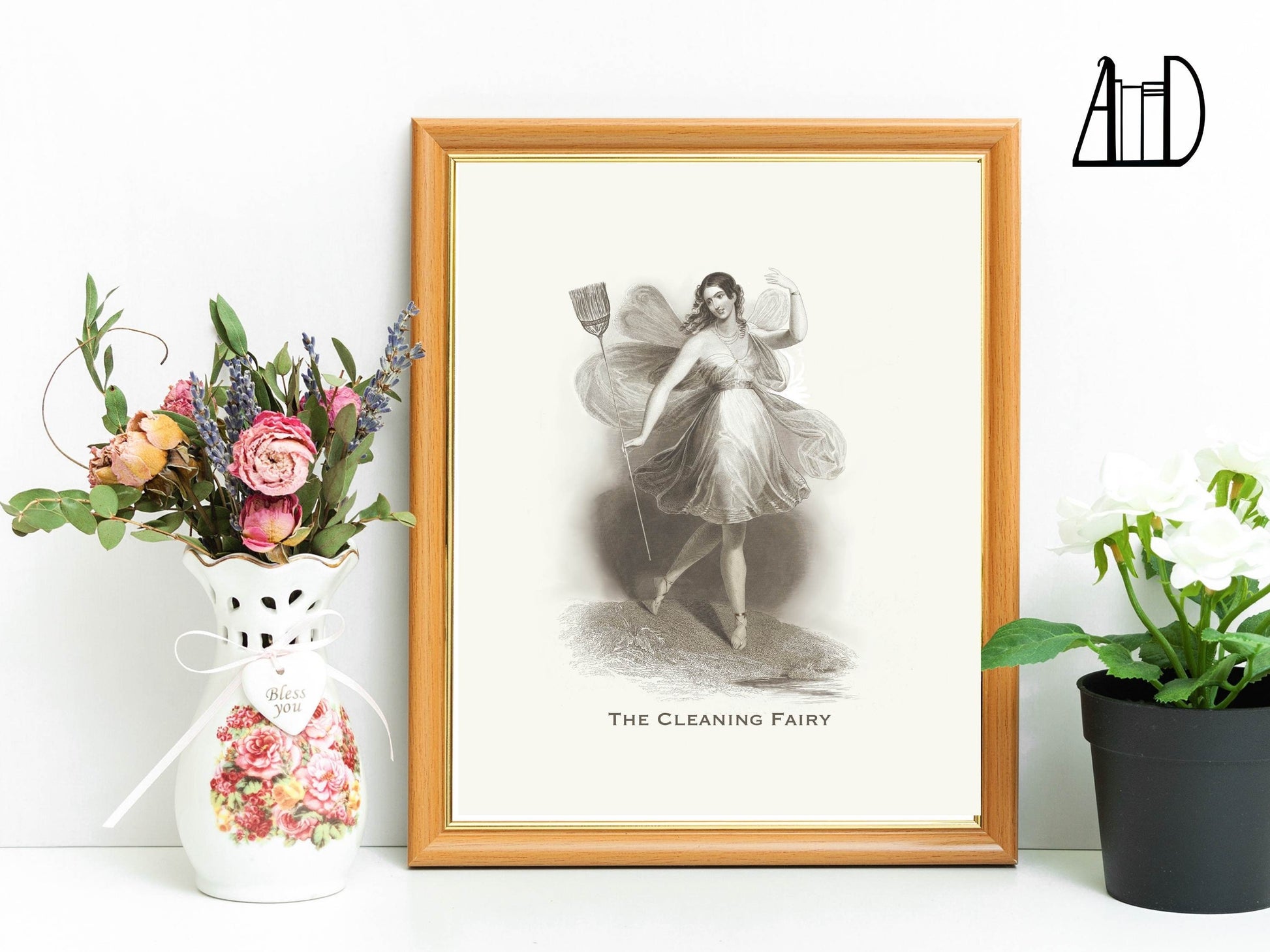 Framed print of the Cleaning Fairy on a shelf with plants. 
